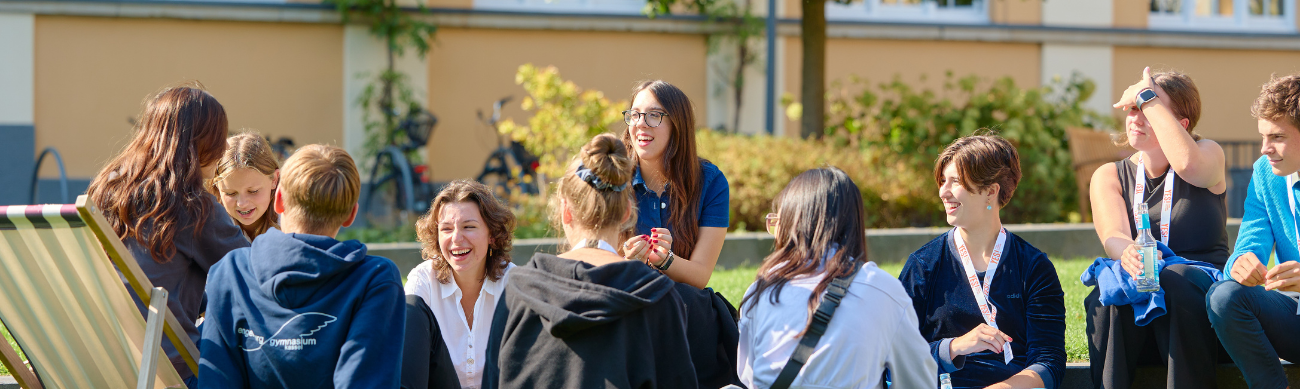 Schüler sitzen auf einer Wiese beim Regionalfinale
